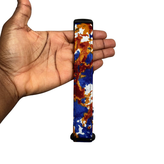 Hand holding a dog collar with a colorful pattern against a white background