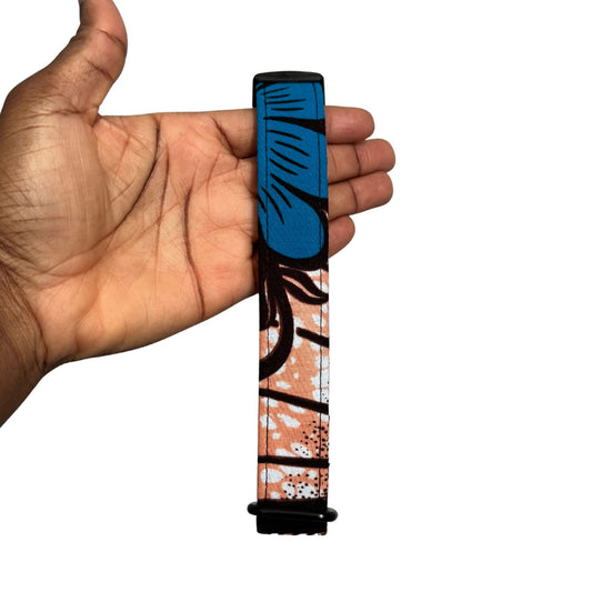 Hand holding a colorful dog collar with black and blue flowery design on a white background