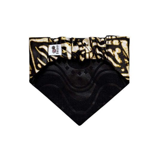 Black and gold patterned dog bandana with a brand label on a white background