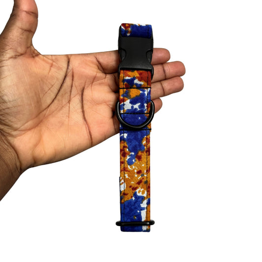 Colorful patterned dog collar held in a hand against a white background
