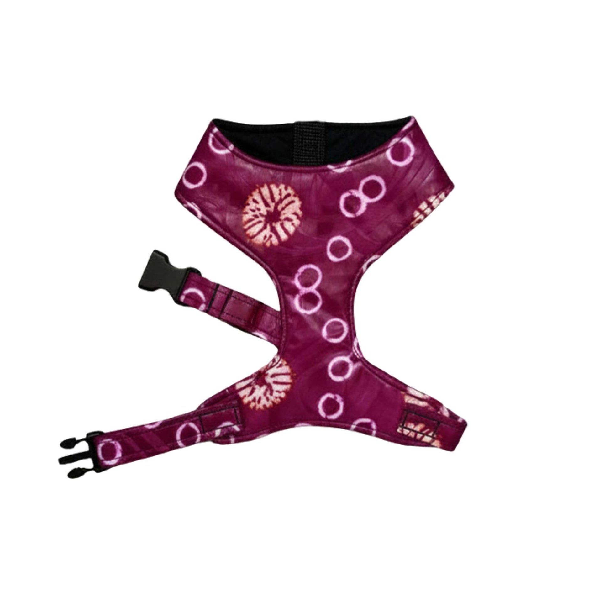 A dog harness with a deep magenta-purple background featuring a white tie-dye style circular and spiral pattern, with black plastic hardware and an adjustable strap.