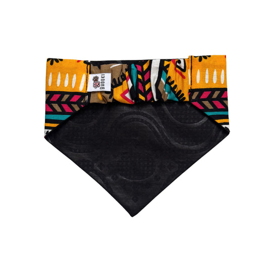 Colorful patterned dog bandana with a black backing on a white background