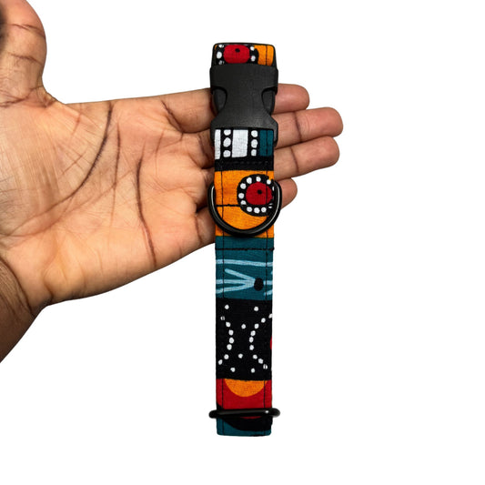 Colorful dog collar with a unique design held in a hand against a white background